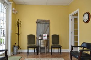 chalfont dentistry waiting room with yellow walls with a displaced wooden door for display